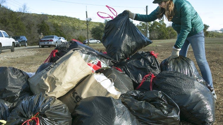 Erin Cord, Community Beautification Coordinator for Keep Austin Beautiful, helps sort trash from recyclables as many volunteers help with the cleanup task Saturday morning. Keep Austin Beautiful, a non-profit organization, hosted their 4th Annual Highway 360 Cleanup Saturday January 9, 2016 to restore the highway back to its unadorned and natural state prior to the holidays. Volunteers nearing 100 spread out from U.S. 183 south to Bee Caves Rd. to un-decorate the many cedar trees of holiday ornaments, etc. What can be saved will be donated to area charities and the trash picked up by the Austin Resource Recovery. RALPH BARRERA/ AMERICAN-STATESMAN