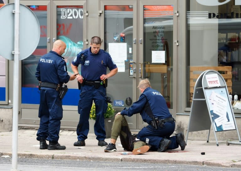 Finnish police officers detain the suspect after he went on the rampage with a knife in the southwestern port city of Turku, killing two and wounding eight