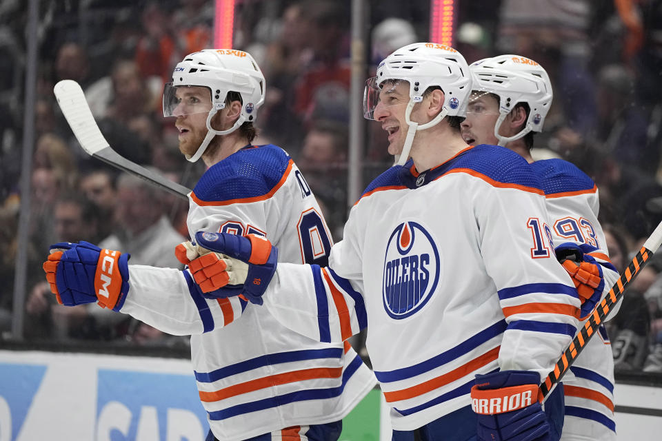 Edmonton Oilers left wing Zach Hyman, center, celebrates his goal with center Connor McDavid, left, and center Ryan Nugent-Hopkins during the third period in Game 3 of an NHL hockey Stanley Cup first-round playoff series against the Los Angeles Kings Friday, April 26, 2024, in Los Angeles. (AP Photo/Mark J. Terrill)