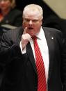 REFILE ADDING THE WORD "DURING" IN FIRST SENTENCE Toronto Mayor Rob Ford gestures during a special council meeting at City Hall in Toronto November 18, 2013. Toronto's City Council voted overwhelmingly on Monday to limit further the powers of embattled Toronto Mayor Rob Ford, who denounced the move as a coup d'etat and warned political foes of an election battle next year to rival the Gulf War. Ford has been under fire after admitting to smoking crack cocaine, buying illegal drugs and driving after drinking alcohol. REUTERS/Aaron Harris (CANADA - Tags: POLITICS DRUGS SOCIETY)