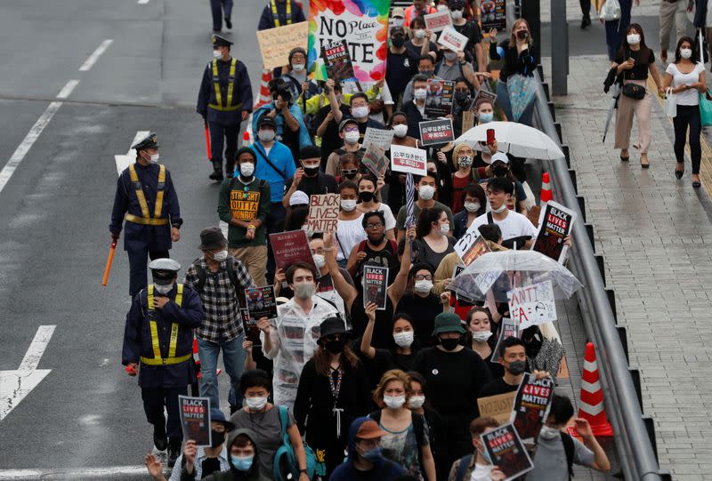 People wearing face masks march during a Black Lives Matter protest following the death in Minneapolis police custody of George Floyd, in Tokyo