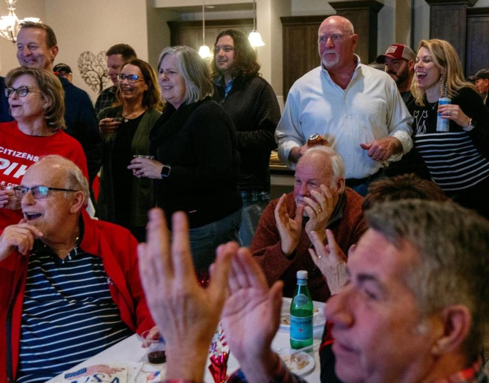 Eagle City Council President Brad Pike, in white, watches as the first results come in during his election night watch party at his home in Eagle.