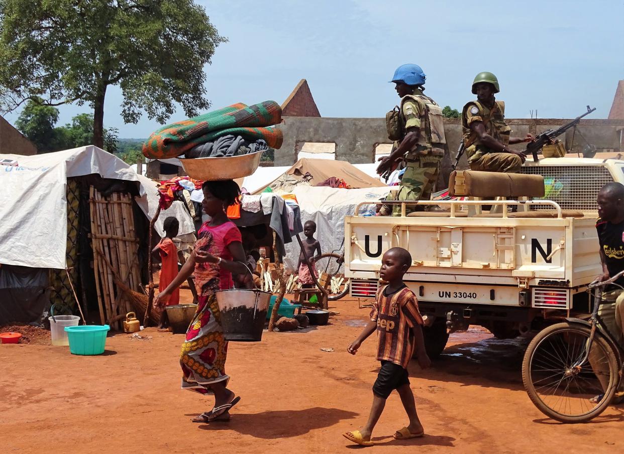 A woman and a child walk past U.N. peacekeepers from Gabon patroling the Central African Republic town of Bria on June 12, 2017. (Photo: Saber Jendoubi/AFP/Getty Images)