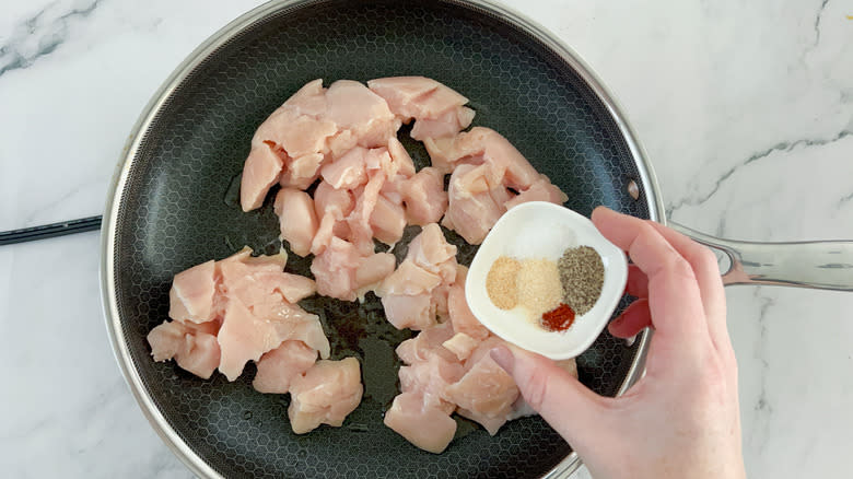 hand seasoning raw chicken