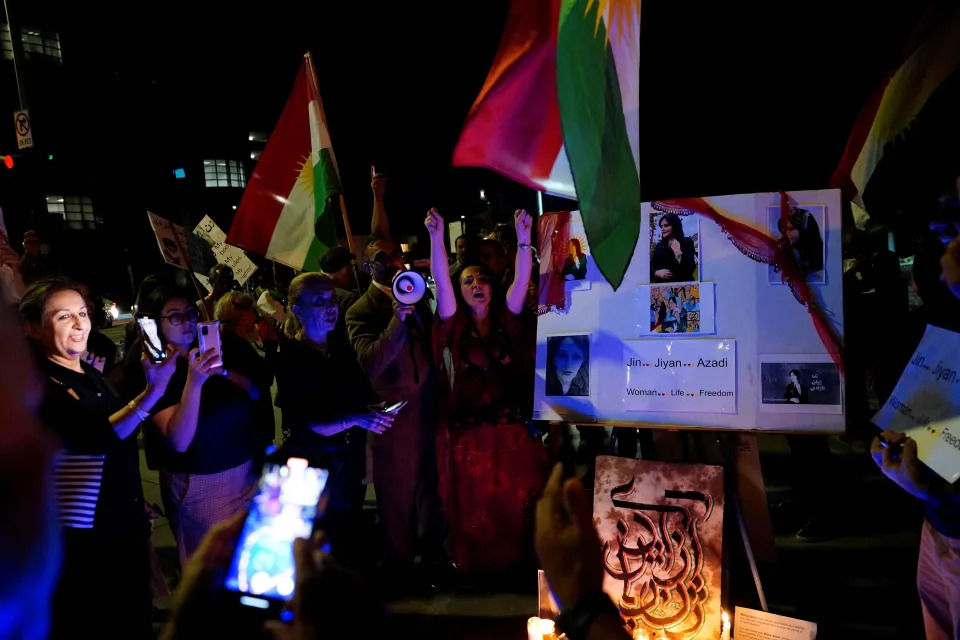 <p>Demonstrators sing the Kurdish national anthem in protest at a candlelit vigil following the death of a young Iranian Kurdish woman, Zhina Mahsa Amini, outside the Wilshire Federal Building in Los Angeles, California, U.S., September 22, 2022. REUTERS/Bing Guan</p> 