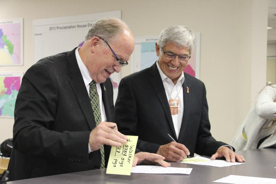 File - In this Aug. 20, 2018 file photo, Alaska Gov. Bill Walker, left, and Lt. Gov. Byron Mallott sign forms at the Division of Elections office in Anchorage, Alaska after the two men submitted signatures to get their ticket on the November general election ballot. The governor of Alaska says Lt. Gov. Byron Mallott has resigned over unspecified "inappropriate comments." The move upends what was already a difficult re-election fight for Gov. Bill Walker. Mallott's decision was announced Tuesday, Oct. 16, 2018, shortly after Walker participated in a debate in Anchorage. (AP Photo/Mark Thiessen, File)