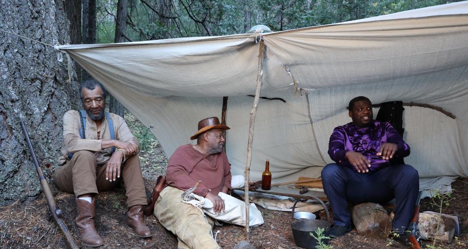 Actors gather on the set of "The Golden Ghosts" while on location in Mount Shasta. The film is a work of historical fiction, and tells the story of two Black men who make their way to California to mine during the Gold Rush. Left to right: Fred Magee (Money), Victor Martin (Tall) and Bob Milhouse (gold miner and preacher).