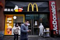 People wearing face masks are seen outside a McDonald's restaurant in Wuhan
