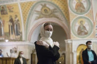 Parishioners wearing face masks and gloves to protect against coronavirus observe social distancing as they attend a service at the Christ the Savior Cathedral in Moscow, Russia, Tuesday, June 2, 2020. Churches in Moscow reopen to believers after a two-month lockdown imposed to control the spread of the coronavirus. (AP Photo/Pavel Golovkin)