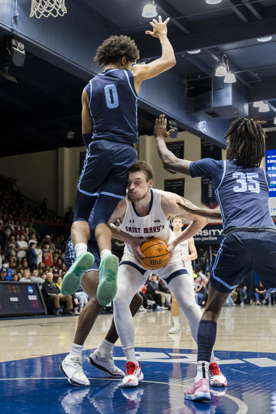 Saint Mary's center Mitchell Saxen, middle, collides with San Diego guard Kevin Patton Jr. (0) as guard Keyon Kensie (35) defends during the first half of an NCAA college basketball game in Moraga, Calif., Saturday, Feb. 24, 2024. (AP Photo/John Hefti)