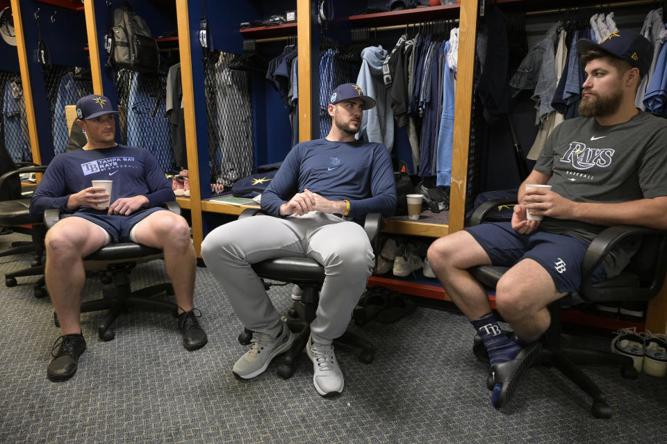 Tampa Bay Rays pitchers Drew Rasmussen, left, Ryan Thompson, center, and Jalen Beeks chat in the clubhouse before the first practice for pitchers and catchers at spring training baseball camp, Wednesday, Feb. 15, 2023, in Kissimmee, Fla. (AP Photo/Phelan M. Ebenhack)