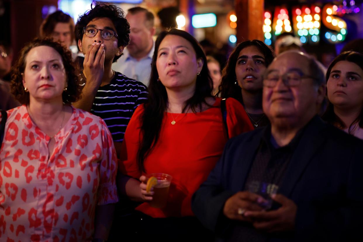 People watch the CNN presidential debate between U.S. President Joe Biden and Republican presidential candidate former President Donald Trump at a debate watch party at Shaws Tavern on June 27, 2024 in Washington, DC.