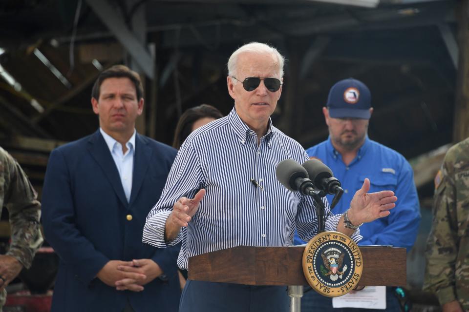 President Biden speaks in a neighborhood impacted by Hurricane Ian in Fort Myers, Florida, on October 5, 2022 as Florida Gov. Ron DeSantis looks on. (Photo by OLIVIER DOULIERY/AFP)