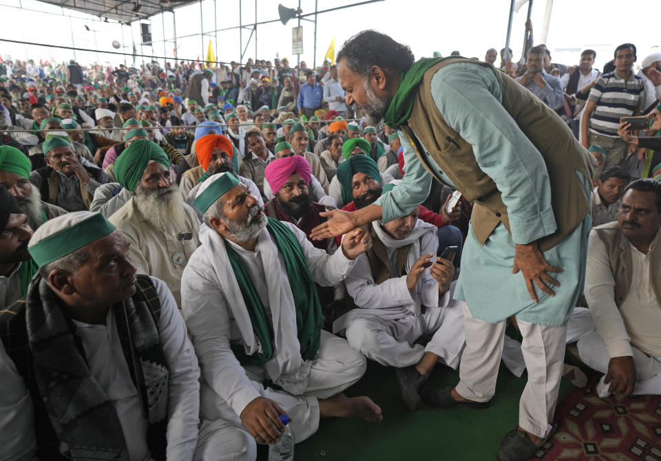 Farmers leader Rakesh Tikait , centre left, talks with activist Yogendra Yadav during a rally at Ghazipur border, in New Delhi, India, Friday, Nov. 26, 2021. Tens of thousands of farmers rallied on Friday marking one year of their movement that forced Prime Minister Narendra Modi to withdraw three agriculture laws that feared would drastically reduce their incomes and leave them at the mercy of corporations.(AP Photo/Manish Swarup)