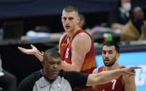 Denver Nuggets center Nikola Jokic, back left, argues for a foul as guard Facundo Campazzo, back right, looks on while referee Tony Brothers, front, walks away in the first half of an NBA basketball game against the New Orleans Pelicans Wednesday, April 28, 2021, in Denver. (AP Photo/David Zalubowski)