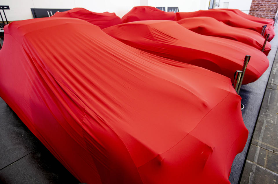 Cars are covered with red blankets at the IAA Auto Show in Frankfurt, Germany, Monday, Sept. 9, 2019. The IAA officially starts with media days on Tuesday and Wednesday. (AP Photo/Michael Probst)