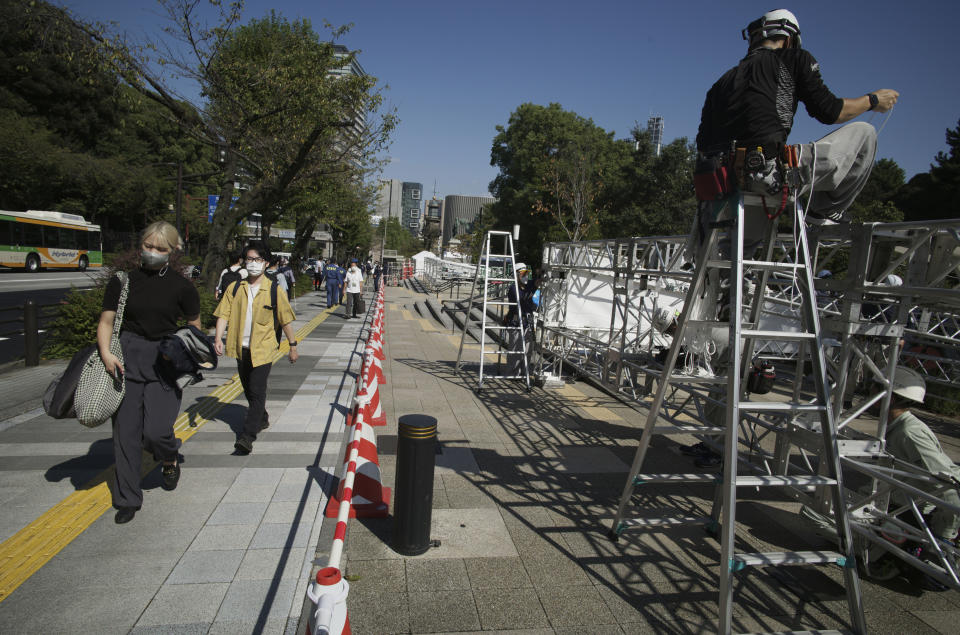 Workers set up an area for books of condolences near the building to be used for the state funeral of former Prime Minister Shinzo Abe in Tokyo, Monday, Sept. 26, 2022. Japanese Prime Minister Fumio Kishida is hosting the controversial state-sponsored ceremony for the former leader Tuesday. (AP Photo/Hiro Komae)