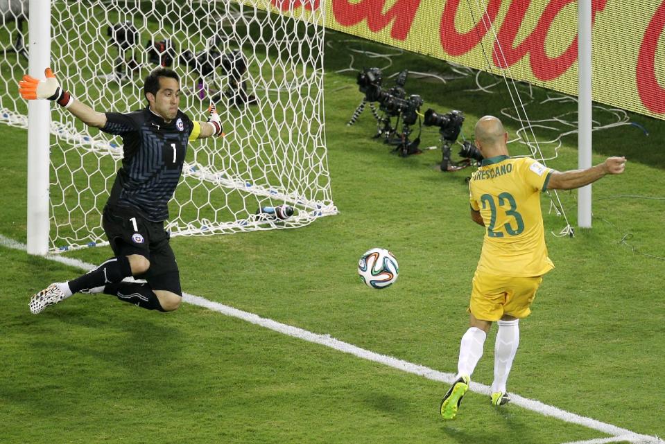 Mark Bresciano, derecha, ante Claudio Bravo durante el partido entre Chile y Australia del Mundial de Brasil 2014. (AP Photo/Michael Sohn)