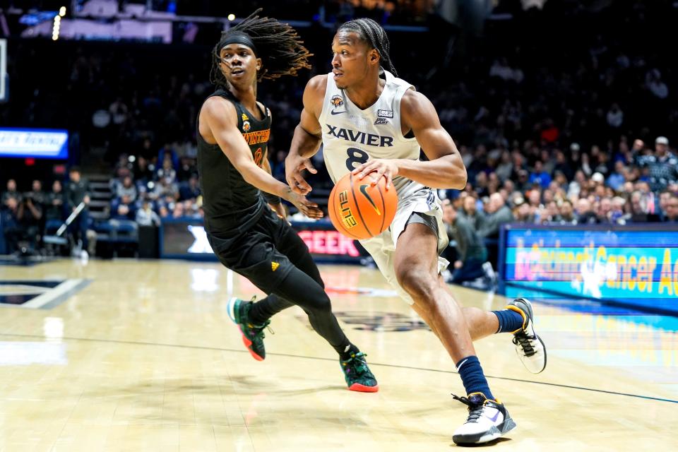 Xavier Musketeers guard Quincy Olivari (8) drives the ball past Winthrop Eagles guard Sin'Cere McMahon (0) in the first half of the NCAA basketball game between the Winthrop Eagles and Xavier Musketeers on Saturday, Dec. 16, 2023, at the Cintas Center in Cincinnati.