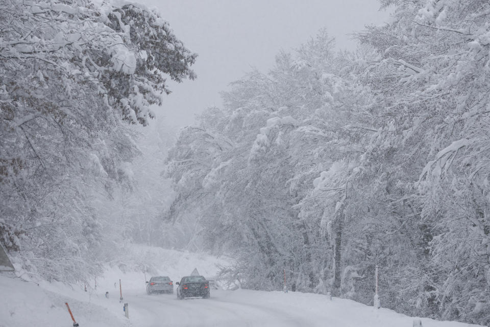 Cars make their way on the snow covered road in Kocevje, near Ljubljana Slovenia, Monday, Jan. 23, 2023. A snow storm with gust winds has hampered traffic on a key highway in Slovenia on Monday and left parts of the country temporarily without electricity. (AP Photo)