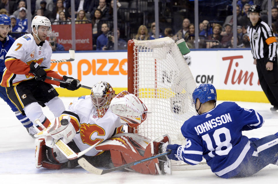 Calgary Flames goaltender David Rittich (33) makes a save against Toronto Maple Leafs left wing Andreas Johnsson (18) during the second period of an NHL hockey game Thursday, Jan. 16, 2020, in Toronto. (Nathan Denette/The Canadian Press via AP)