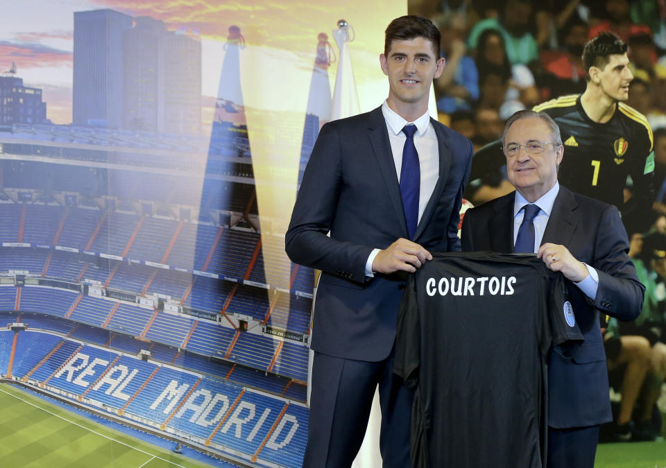 Belgian new Real Madrid soccer player Thibaut Courtois, left, and Real Madrid President Florentino Perez pose for the media during his official presentation for Real Madrid at the Santiago Bernabeu stadium in Madrid, Thursday, Aug. 9, 2018. Chelsea has sold a player — goalkeeper Thibaut Courtois — to Real Madrid. The Belgian was replaced by Kepa Arrizabalaga after Chelsea met the goalkeeper's 80 million euro ($93 million) buyout clause from Athletic Bilbao on Wednesday. (AP Photo/Andrea Comas)