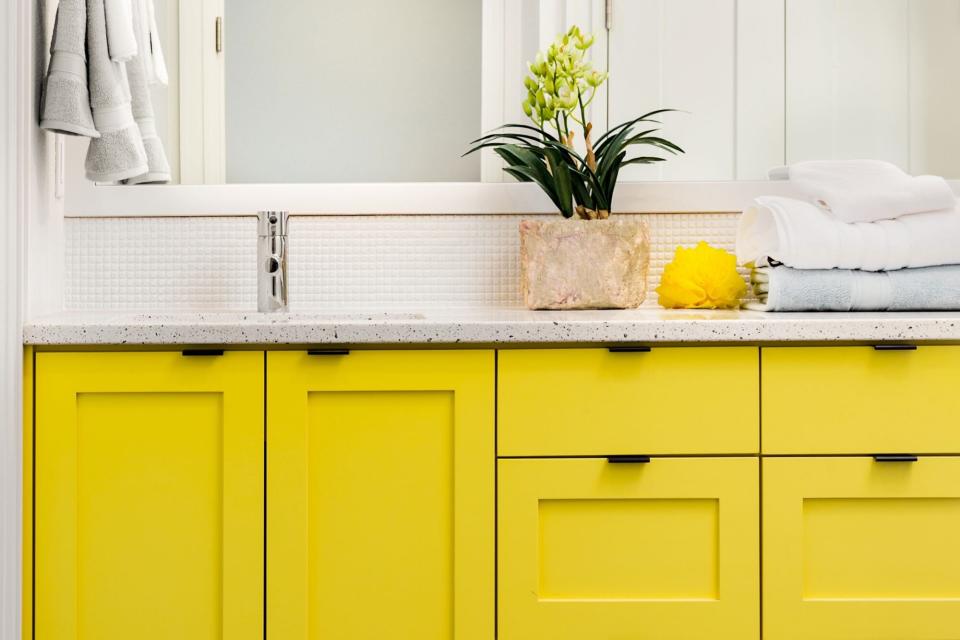 Bright yellow cabinets in bathroom