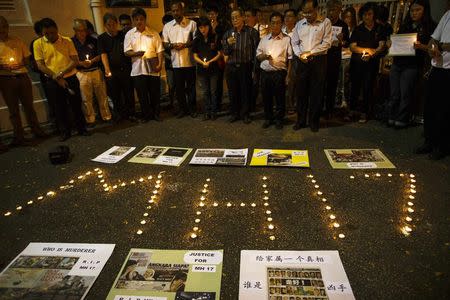 People hold candles during a candlelight vigil for victims of the downed Malaysia Airlines Flight MH17, in Kuala Lumpur July 19, 2014. REUTERS/Athit Perawongmetha