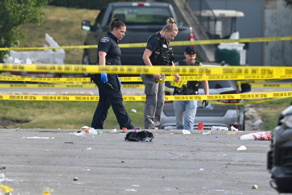 Investigators look over the scene of an overnight mass shooting at a strip mall in Willowbrook, Illinois, Sunday, June 18, 2023