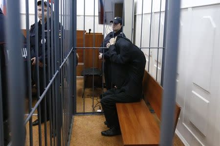 Abror Azimov, a suspect over the recent bombing of a metro train in St. Petersburg, covers his face inside the defendant's cage as he attends a court hearing in Moscow, Russia, April 18, 2017. REUTERS/Sergei Karpukhin