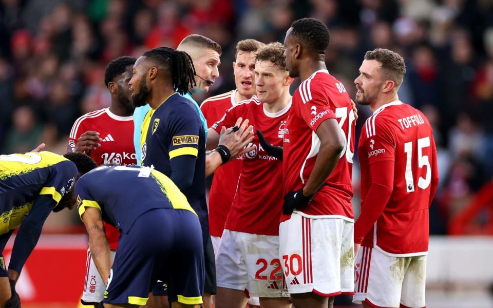 Referee Robert Jones speaks with Willy Boly of Nottingham Forest and his teammates after showing Willy Boly a red card following a second yellow card during the Premier League match between Nottingham Forest and AFC Bournemouth