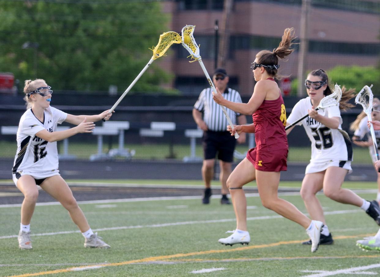 Ithaca's Shea Baker is defended by Corning's Katie Grottenthaler (12) and Sydne Franceschelli during the Hawks' 13-10 win in the Section 4 Class AA girls lacrosse championship game May 25, 2022 at Corning-Painted Post High School.