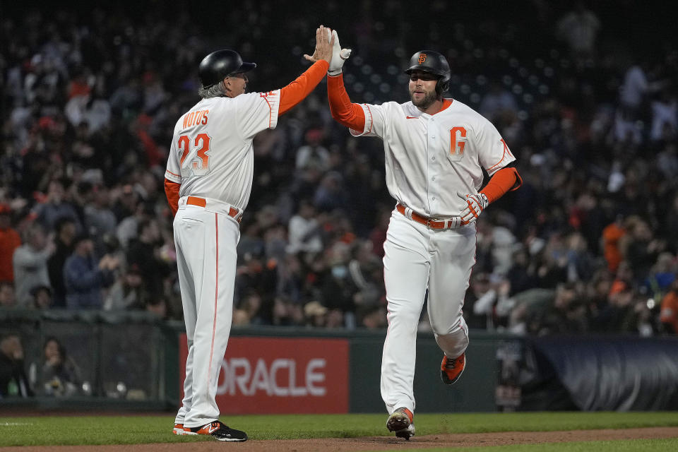 San Francisco Giants' Darin Ruf is congratulated by third base coach Ron Wotus (23) as he rounds the bases after hitting a solo home run against the Washington Nationals during the fifth inning of a baseball game Friday, July 9, 2021, in San Francisco. (AP Photo/Tony Avelar)