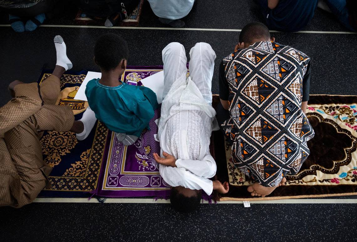 A boy lies on his back with his hands over his face during a prayer led by Imam Abdulhakim Mohammed for a celebration of the Islamic holiday, Eid al-Adha, at what will soon be the new Islamic Center on Montana Avenue in Tacoma, on Saturday, July 9, 2022.