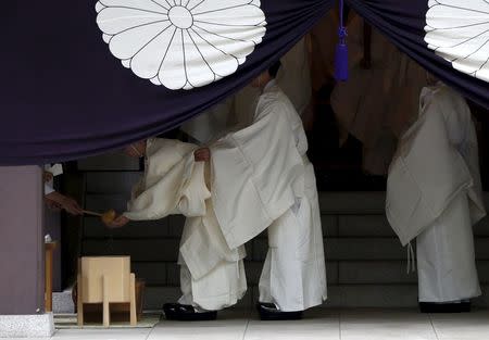 Shinto priests holding traditional umbrellas prepare to walk to the main shrine for a ritual to cleanse themselves during the annual Spring Festival at the Yasukuni Shrine in Tokyo, Japan, April 21, 2016. REUTERS/Issei Kato