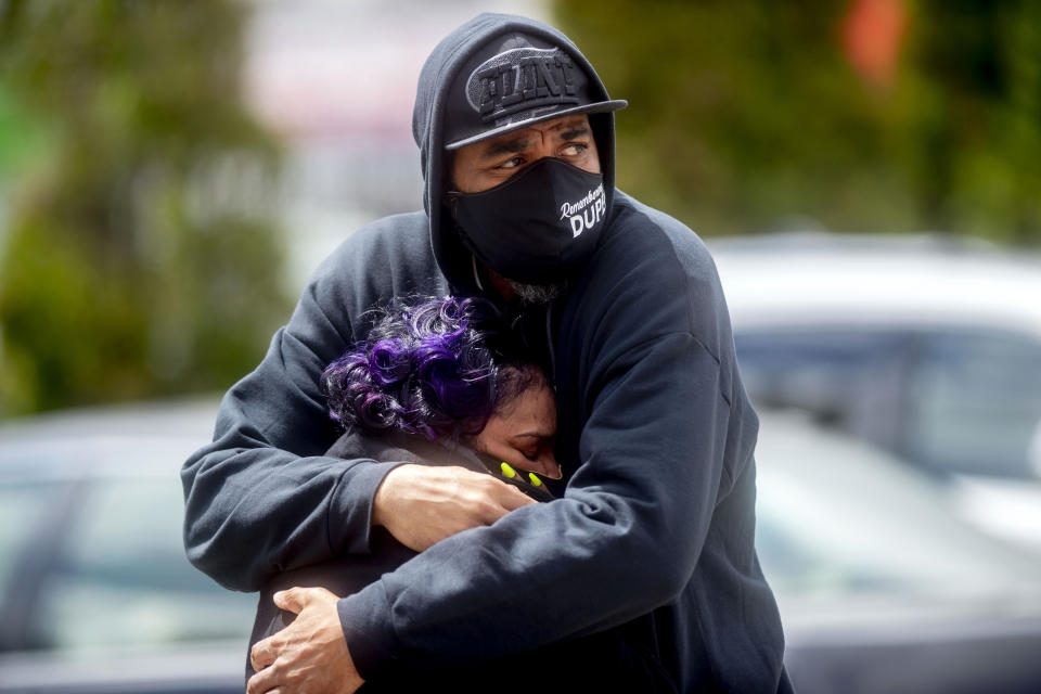 Buhda Nicholas consoles his sister Tawana Beaugard, both of Flint, as they prepare to say goodbye to their cousin during the visitation service for Calvin Munerlyn Friday, May 8, 2020 at Sheldon T. Banks Funeral Chapel in Flint, Mich. Munerlyn, 43, of Flint was shot at the Family Dollar store following an alleged verbal altercation with 45-year-old Sharmel Teague after he told the woman's daughter she needed to wear a mask while inside. (Jake May/The Flint Journal, MLive.com via AP)