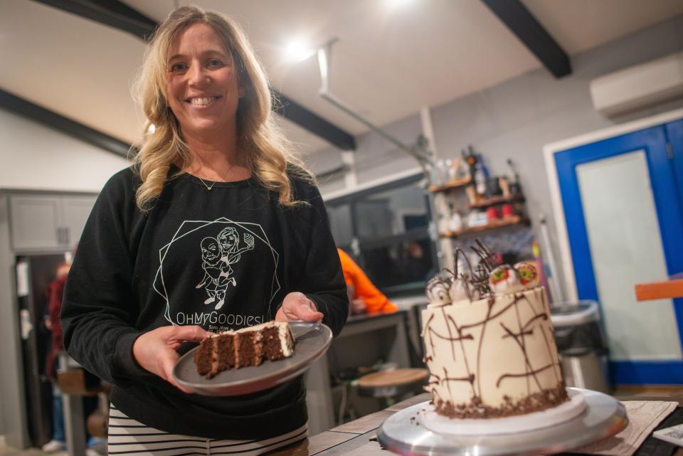 Sara Jean, owner of OhMyGoodies LLC, presents a slice of what she says is her take on a "death by chocolate" cake Wednesday from her kitchen where she makes all her custom cakes. Since 2021, Jean has been making custom cakes and selling them by order through her Facebook page.