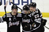 New Jersey Devils left wing Jesper Bratt (63) celebrates after his winning goal with Jack Hughes (86) and Michael McLeod (20) during the overtime period of an NHL hockey game against the Vancouver Canucks, Monday, Feb. 6, 2023, in Newark, N.J. (AP Photo/Bill Kostroun)