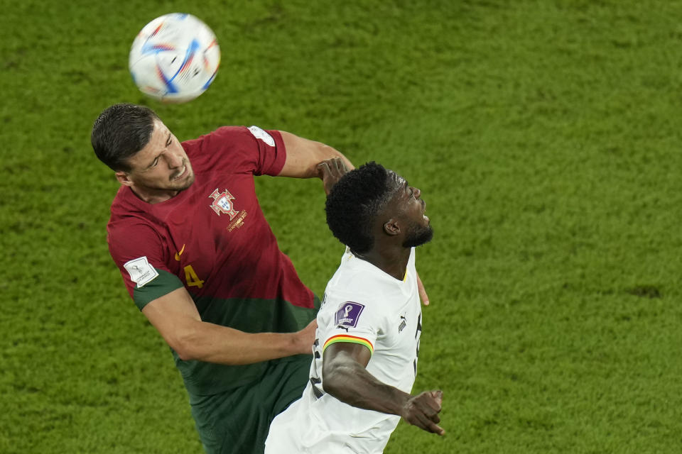 Portugal's Ruben Dias, left, and Ghana's Inaki Williams challenge for the ball during the World Cup group H soccer match between Portugal and Ghana, at the Stadium 974 in Doha, Qatar, Thursday, Nov. 24, 2022. (AP Photo/Francisco Seco)