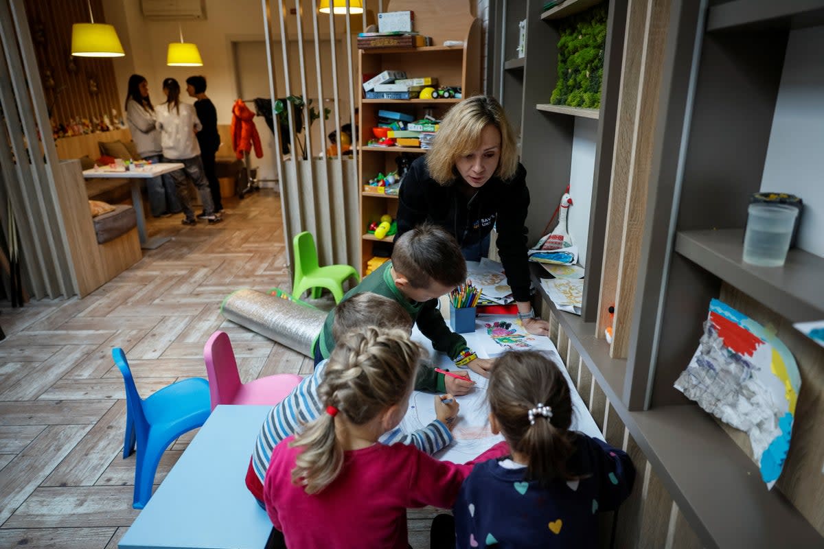 A volunteer of Save Ukraine paints with rescued children, in Kyiv, Ukraine (Reuters)