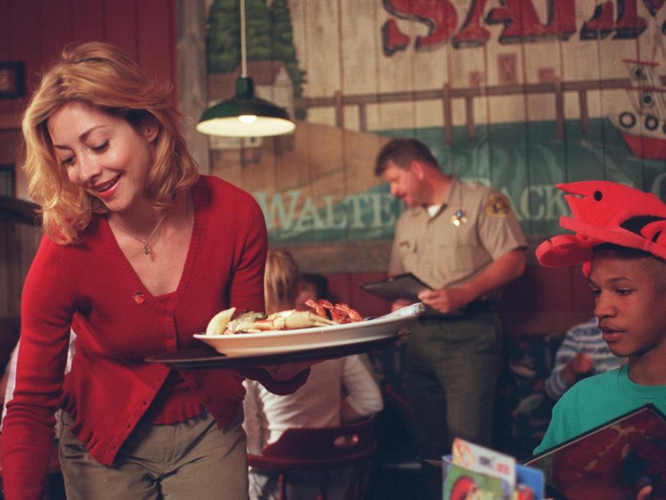 A Red Lobster waitress delivers food to a table in the early 2000s