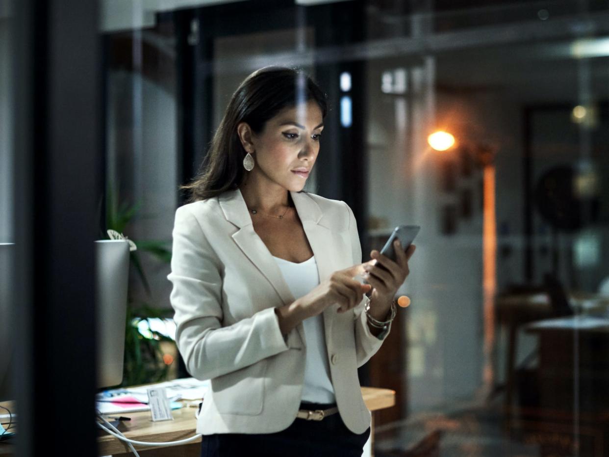 business woman looking at phone in office