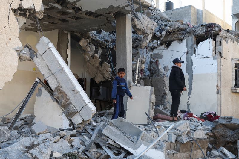 Palestinos inspeccionan el lugar de un ataque israelí contra una casa en Rafah, en el sur de la Franja de Gaza