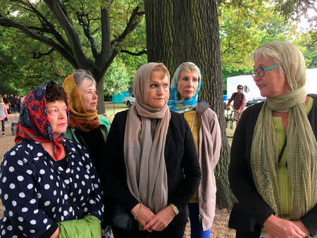 Robyn Molony (R), 65, wears a headscarf with her friends as they take their regular walk opposite Al Noor mosque in Christchurch, New Zealand, March 22, 2019. REUTERS/Tom Westbrook