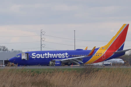 Emergency personnel monitor the damaged engine of Southwest Airlines Flight 1380, which diverted to the Philadelphia International Airport this morning after the airline crew reported damage to one of the aircraft's engines, on a runway in Philadelphia, Pennsylvania U.S. April 17, 2018. REUTERS/Mark Makela