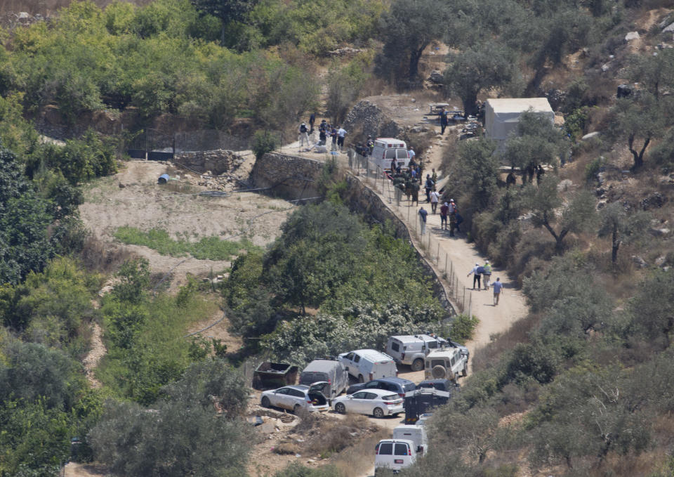 A body is prepared to be evacuated from the sight of an explosion near the Israeli settlement of Dolev, west of the West Bank city of Ramallah, Friday, Aug. 23. 2019. An explosion Friday near a West Bank settlement that Israel said was a Palestinian attack killed a 17-year-old Israeli girl and wounded her brother and father, Israeli authorities said. (AP Photo/Nasser Nasser)