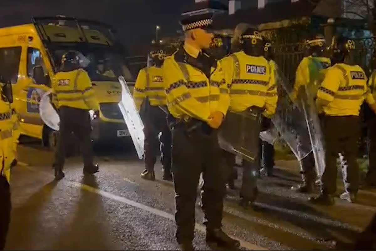 Merseyside Police are seen in riot gear outside the hotel