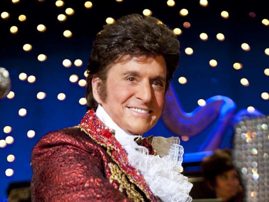 Michael Douglas as Liberace smiling in ruffled shirt