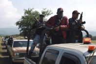 Members of the so-called self-defense group known as United Towns or Pueblos Unidos, gather for a rally in Nuevo Urecho, in the Mexican western state of Michoacan, Saturday Nov. 27, 2021. Extortion of avocado growers in western Mexico has gotten so bad that 500 vigilantes from the "self-defense" group gathered Saturday and pledged to aid police. (AP Photo/Armando Solis)