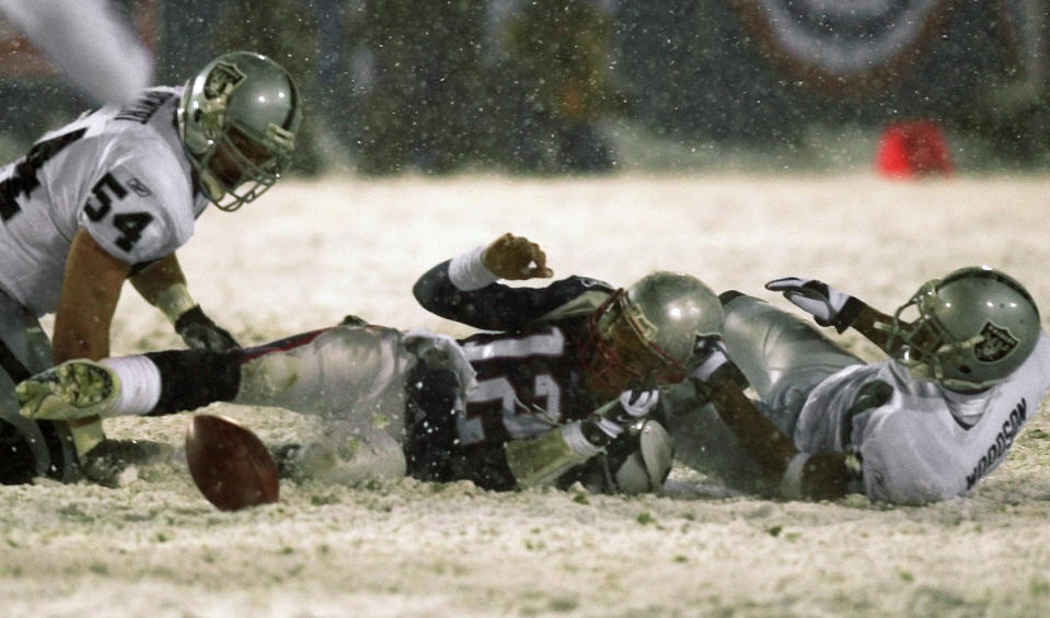 File-New England Patriots quarterback Tom Brady (12) loses the ball after being brought down by Oakland Raiders' Charles Woodson, right, while Greg Biekert (54) moves to recover the ball in the fourth quarter of their AFC Division Playoff game in Foxboro, Mass. Saturday night, Jan. 19, 2002. The play was appealed, and the Patriots retained possession. Raiders coach Jon Gruden says opening this season at Carolina and then playing New Orleans on made him feel like he was in a time warp. His nostalgia is even more amplified this week against New England. It’s been nearly two decades since he walked out of a snow-covered Foxboro Stadium on the wrong end of a 16-13 overtime loss to the Patriots in the infamous “tuck rule” game during the 2001 playoffs. (AP Photo/Elise Amendola, File)